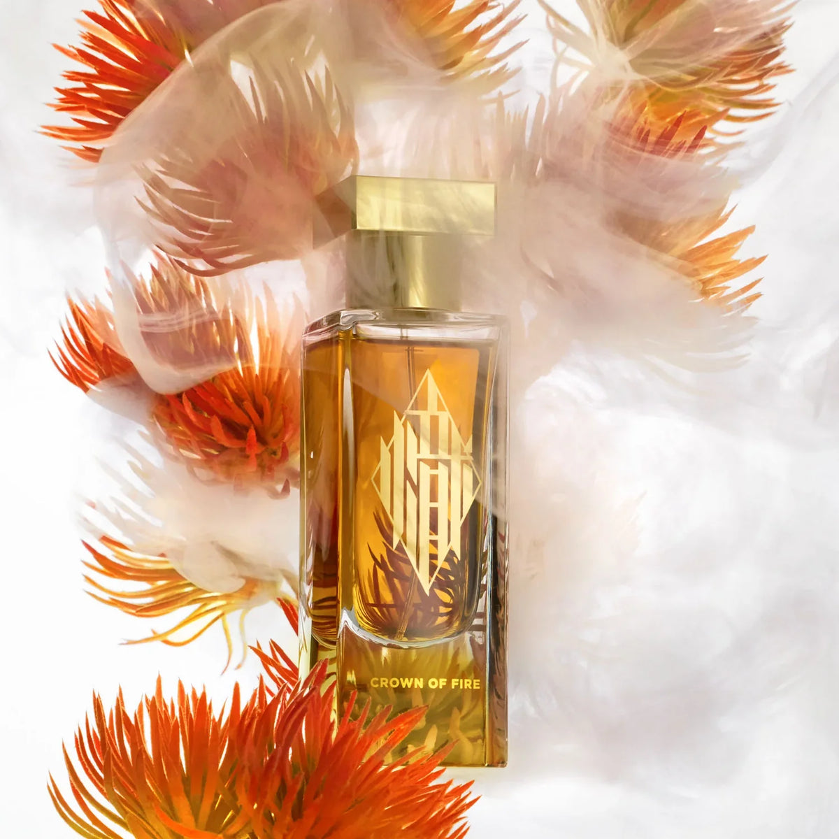 Azman Crown of Fire extrait de parfum bottle among orange blooms and feathers