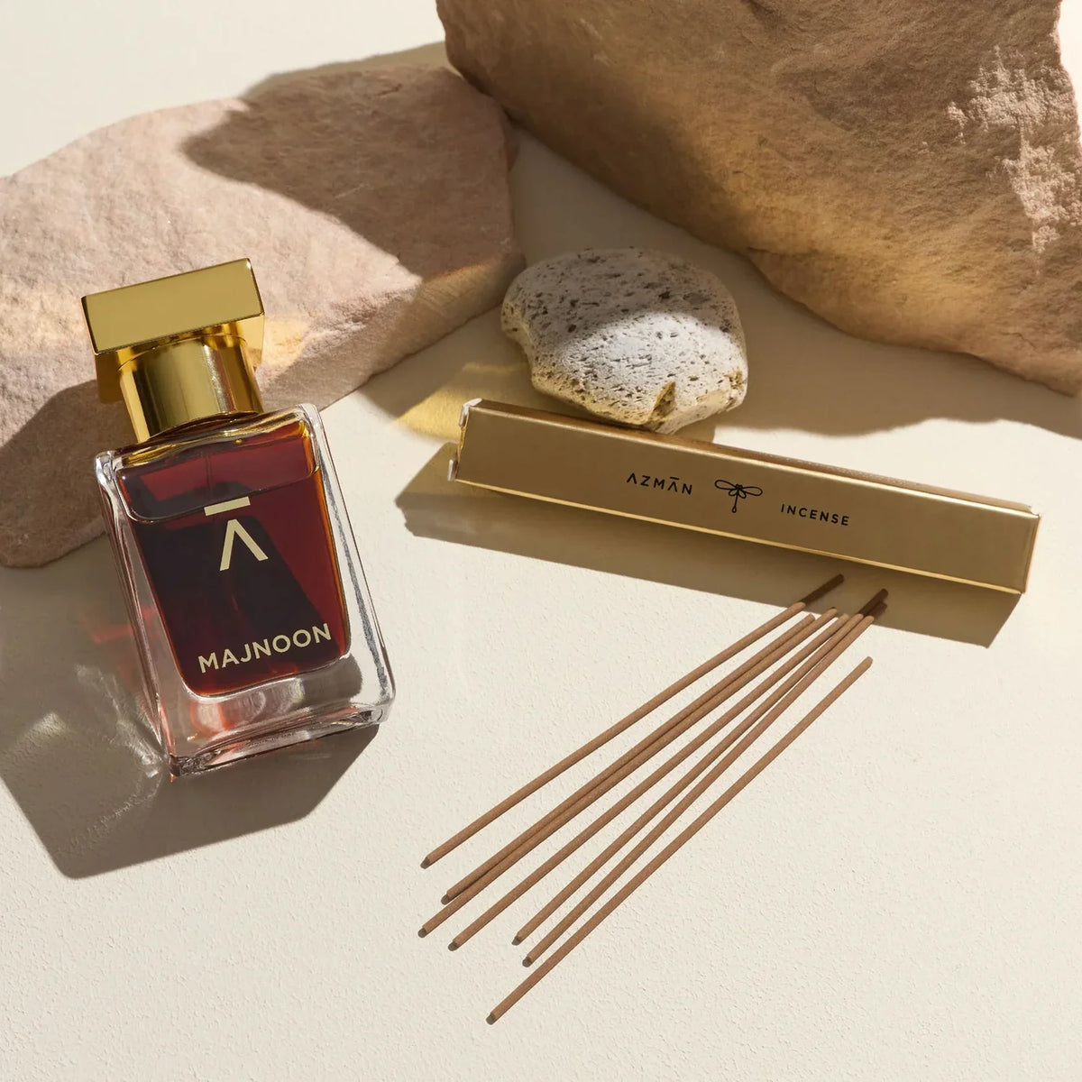 Azman Majnoon parfum bottle beside the house incense sticks on desert stone