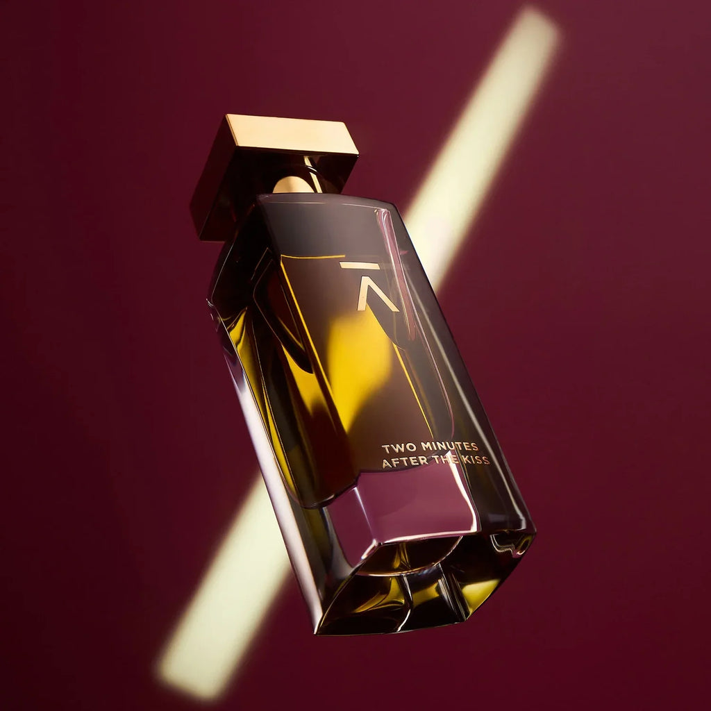 Azman Two Minutes After The Kiss parfum bottle on burgundy with a shaft of light