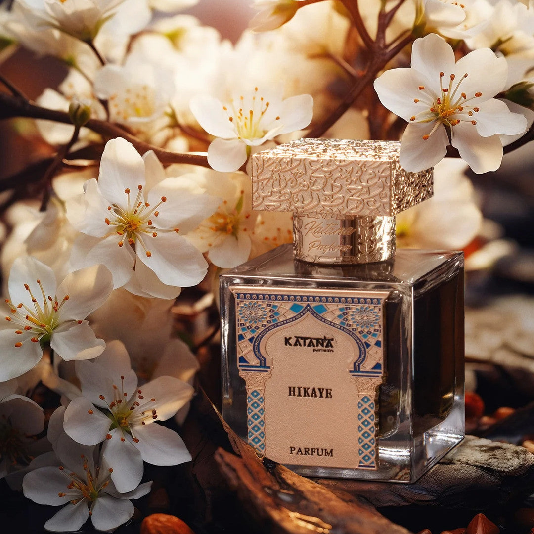 Katana Parfums Hikaye parfum bottle among white blossoms