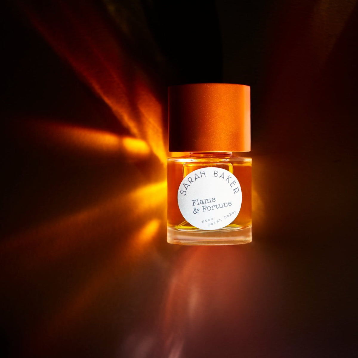 Sarah Baker Flame & Fortune lit from behind in amber light
