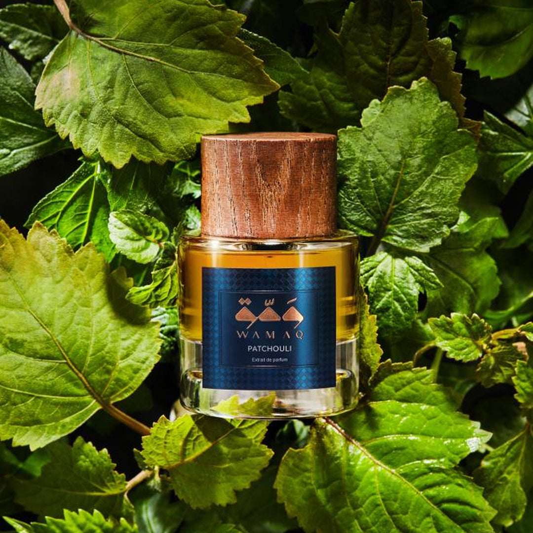 Wamaq Patchouli Extrait de Parfum bottle among patchouli leaves