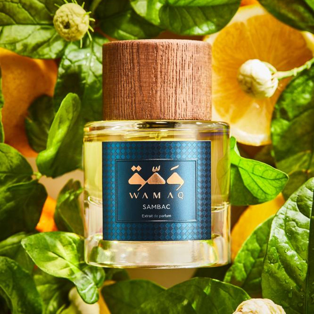 Wamaq Sambac Extrait de Parfum bottle among jasmine sambac buds and orange slices
